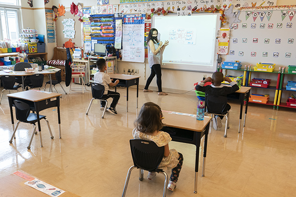 Lisa DiRenzo gives her students instructions as they sit in desks spaced for proper social distance at the Post Road Elementary School, Thursday, Oct. 1, 2020, in White Plains, N.Y. (AP Photo/Mary Altaffer)