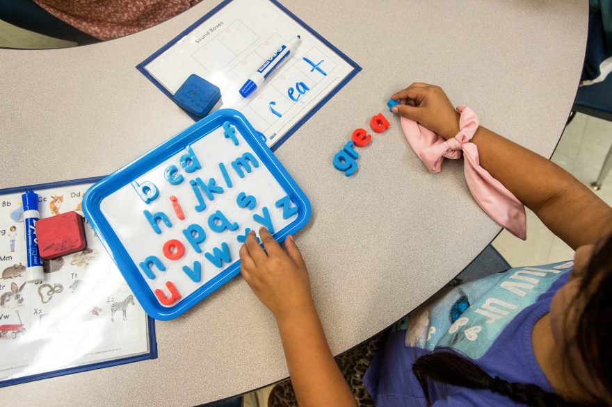 Image of a young student working with letter magnets.