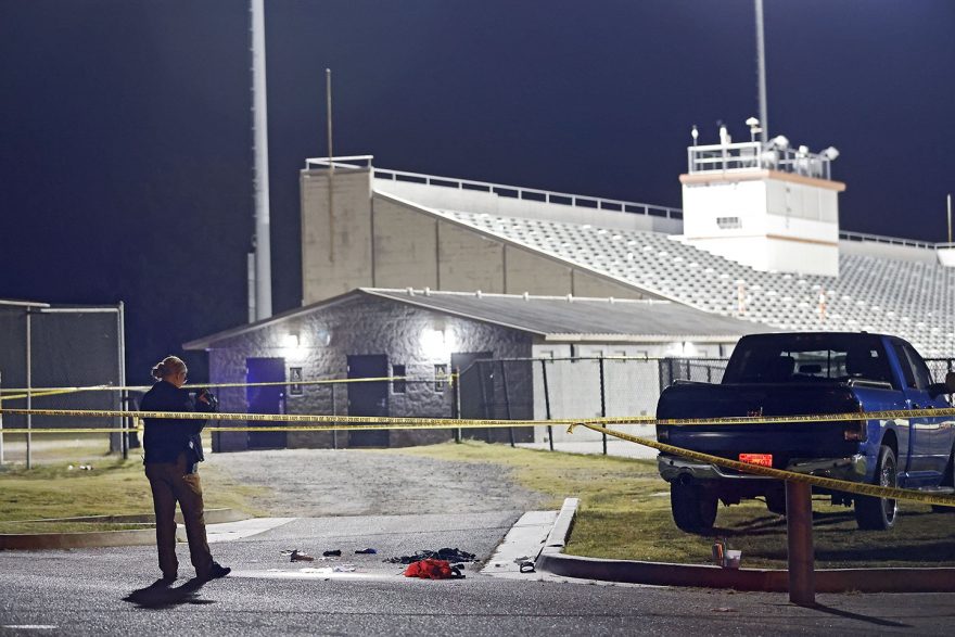 A Tulsa Police officer films the area outside of the McLain High School football stadium after a shooting during a football game Friday, Sept. 30, 2022 in Tulsa, Okla. Police say a teenager was killed and another was wounded in a shooting at a high school homecoming football game in Oklahoma Friday night. (Mike Simons/Tulsa World via AP)